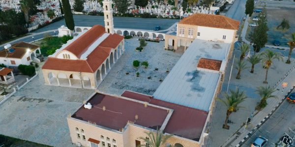 Stunning aerial view of a church with red roof in an urban setting surrounded by greenery.